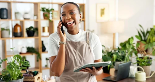 A female small business owner on the phone at the front counter.